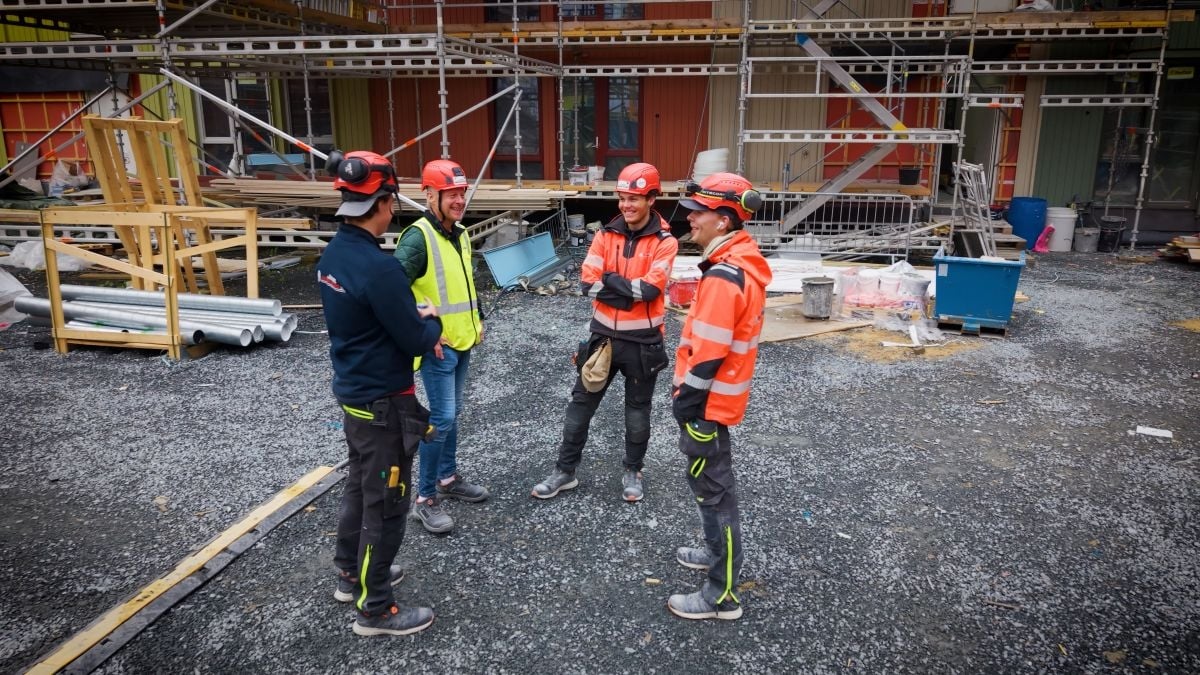 Byggearbeidere snakker sammen på byggeplass