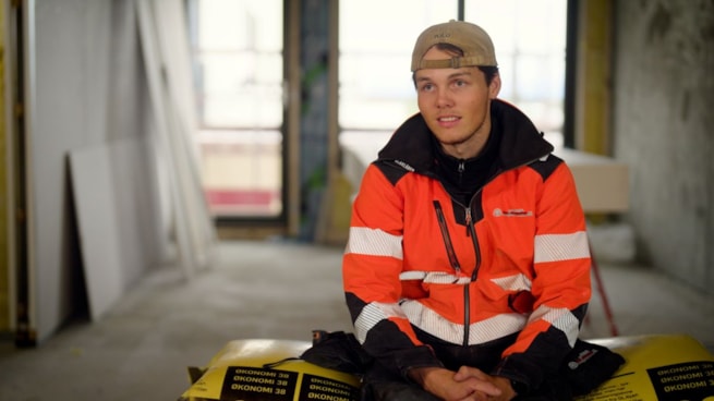 Tømrer som sitter på en pall med isolasjon